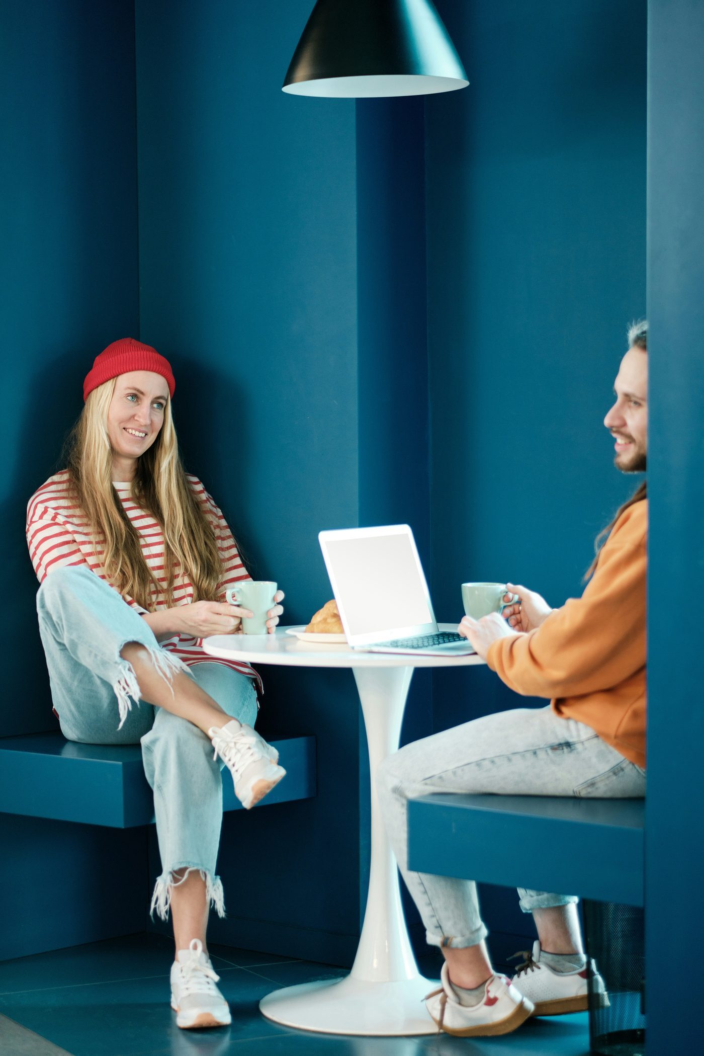 Two colleagues talking in a teal office booth